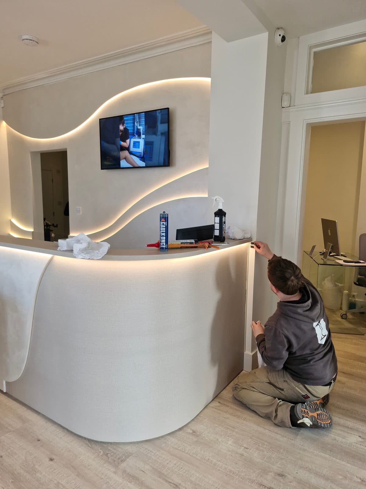 The finished curved reception desk being installed at Bank Medi Spa