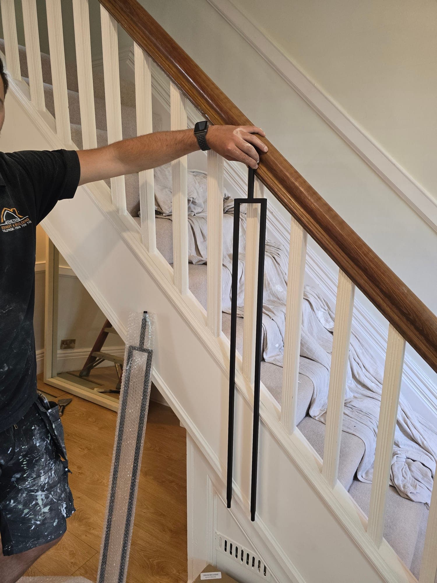 The new black metal balustrade being fitted to the staircase