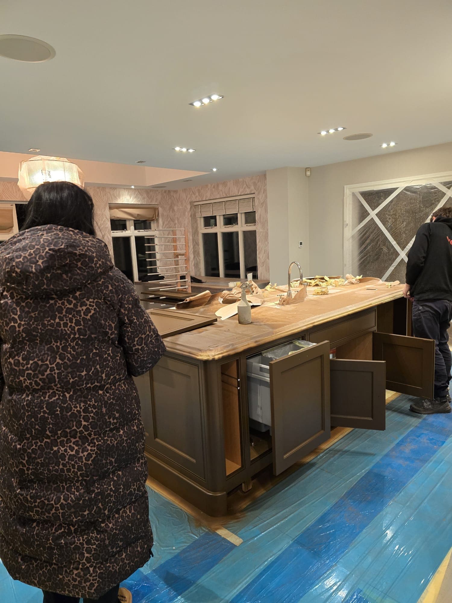 Steph on site as the island is hand-painted, with the worktop papered and the doors off