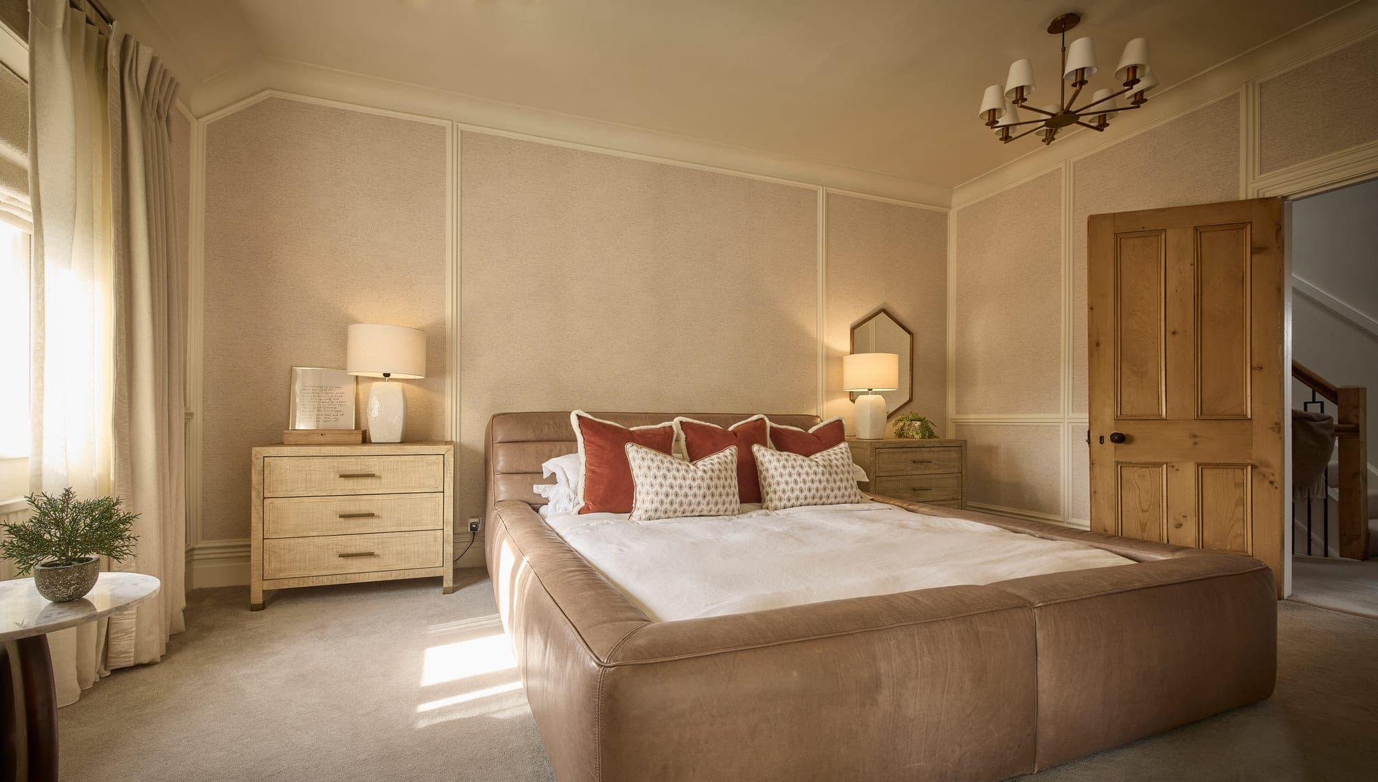 The finished headboard wall in the principal bedroom in Hale, with fluted panelling, grasscloth and a leather bed