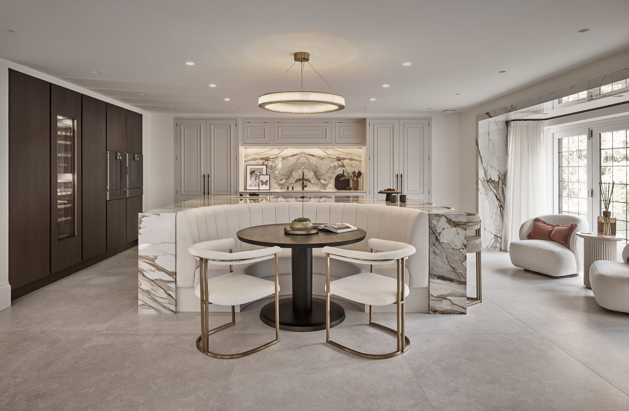 A marble kitchen with a curved breakfast banquette in a Cheshire home
