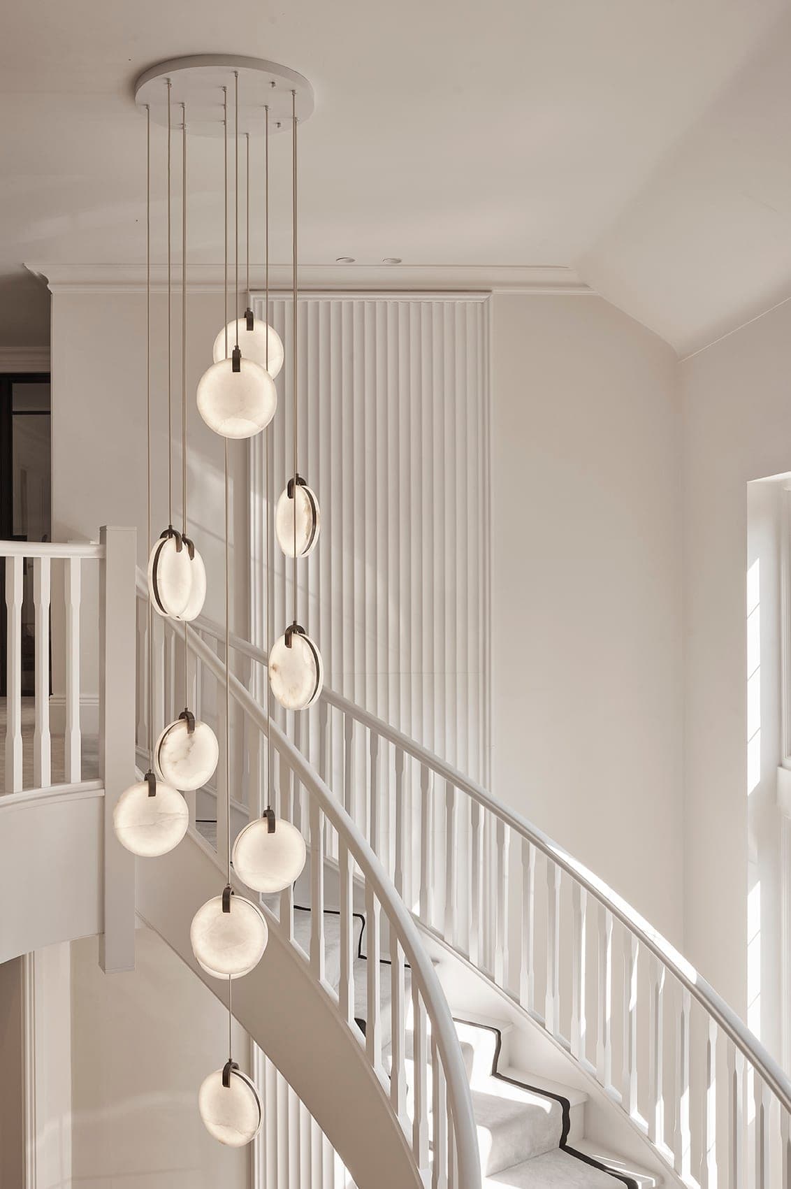 A stairwell with layered lighting in a Prestbury family home