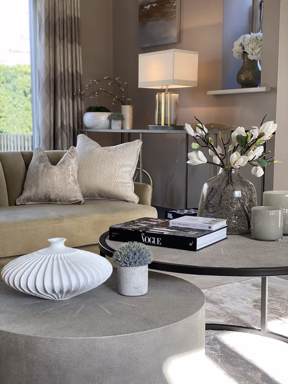 A coffee table styled with a tray, books, a candle and something sculptural